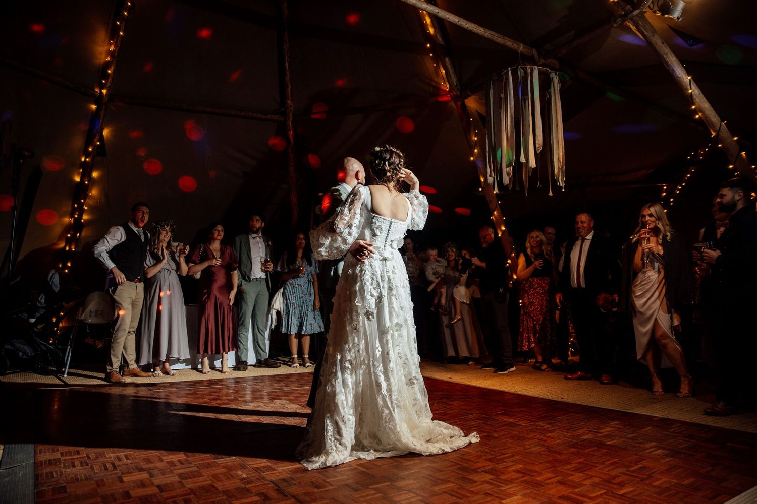 Wedding reception dance floor scene with warm lighting and festive atmosphere.