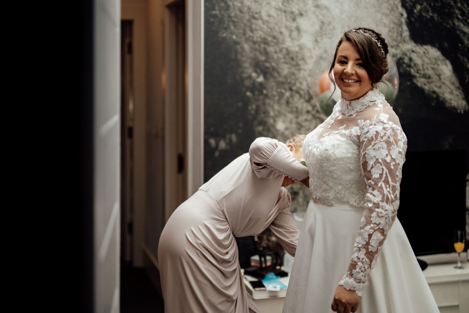 Wedding preparations with white gowns and lace details in an indoor setting.