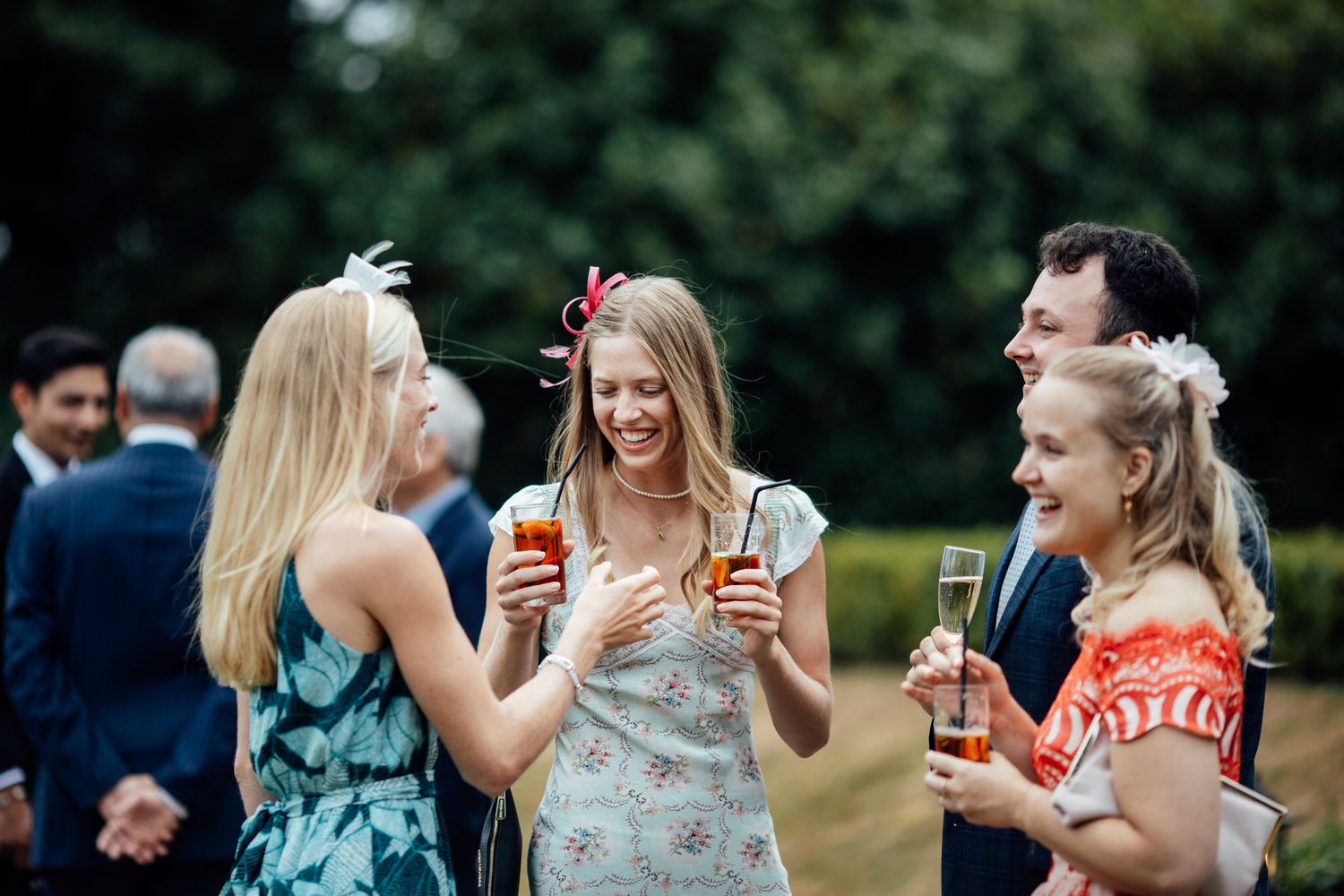 Wedding guests enjoying drinks and conversation during an outdoor cocktail reception.