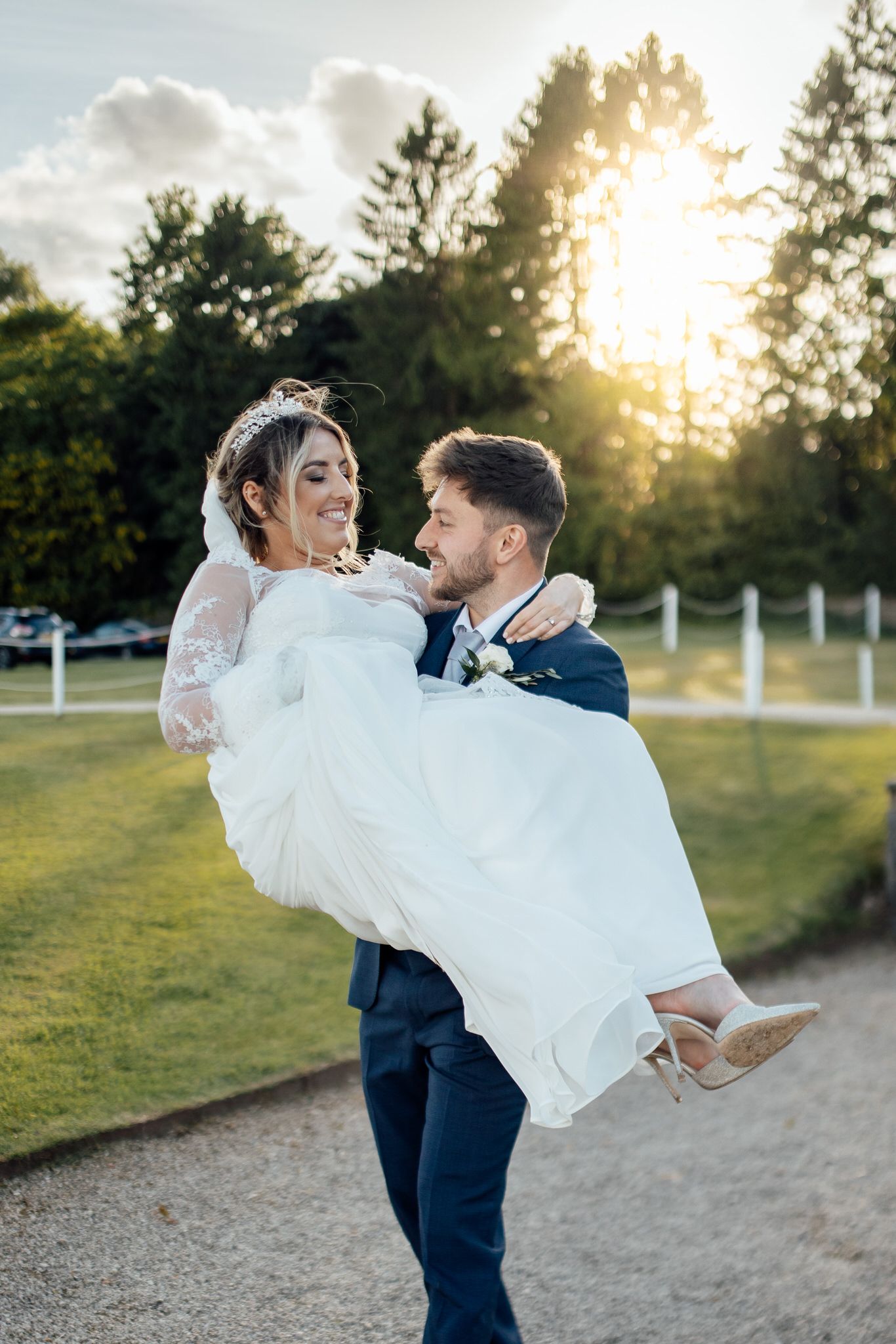 Romantic sunset wedding portrait with couple dancing in an outdoor garden setting.
