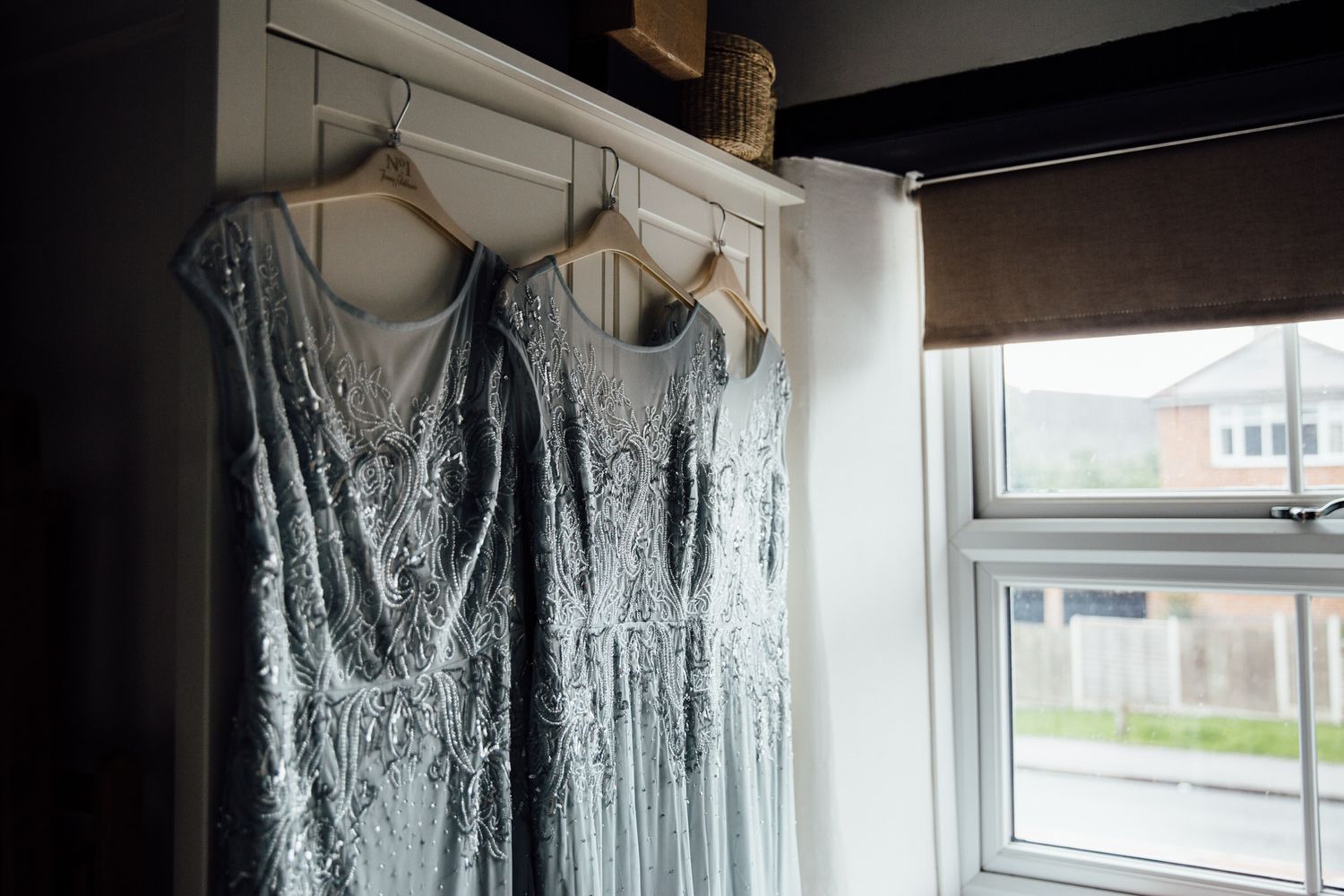 Silver sequined bridesmaid dresses hanging on display in preparation for a wedding.