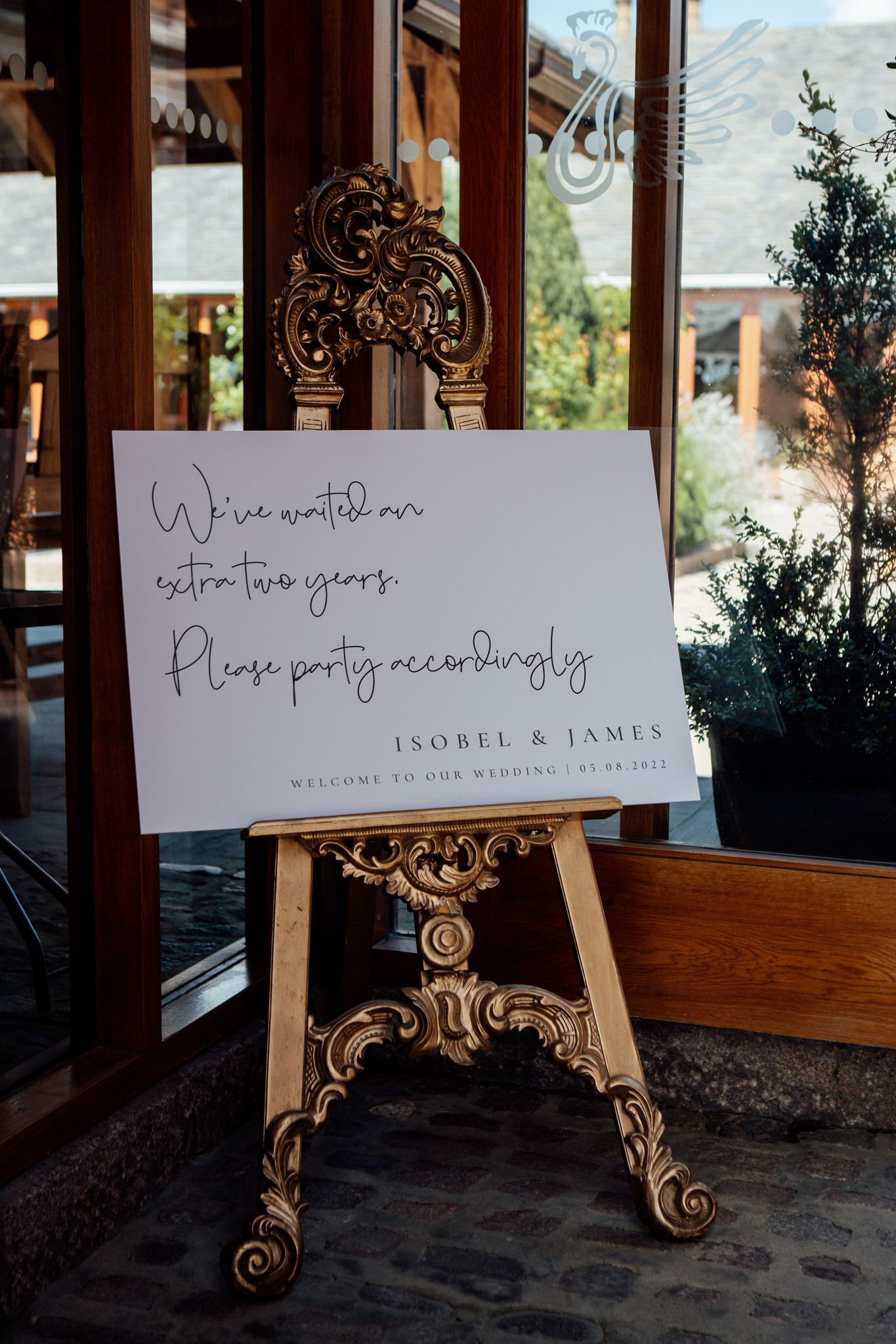 Wedding welcome signs displayed on ornate gold stands with elegant calligraphy.