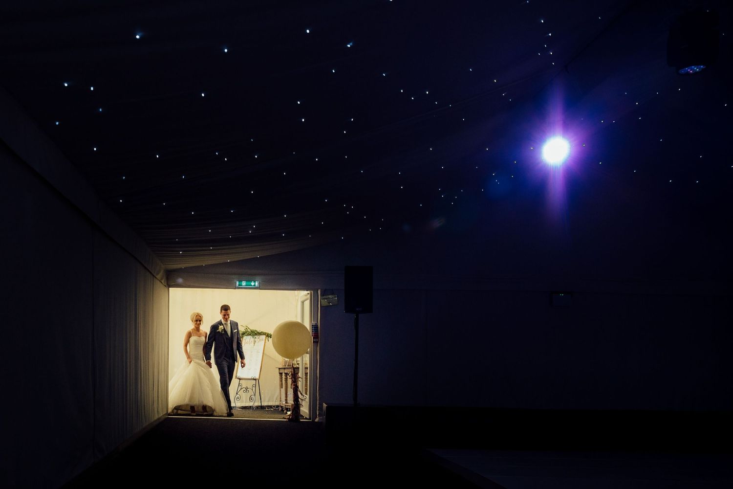 Silhouetted figures in a doorway with starry lighting effects.