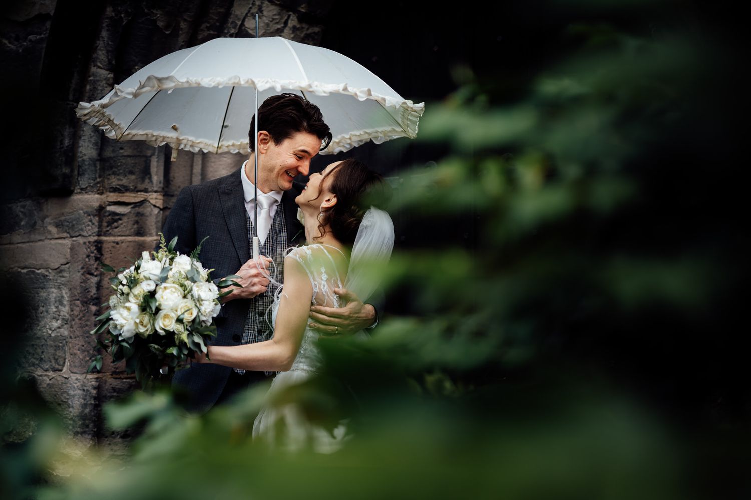 Romantic outdoor wedding portraits with soft bokeh effects and natural greenery.