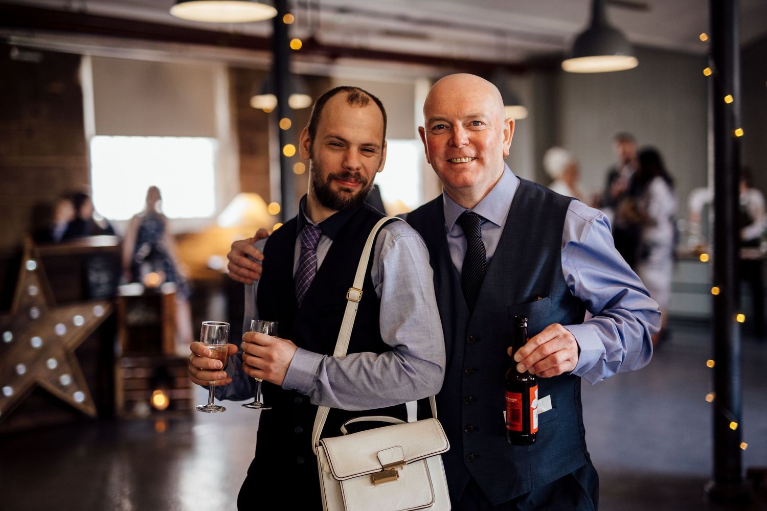 Wedding guests mingling and socializing during an indoor reception celebration.