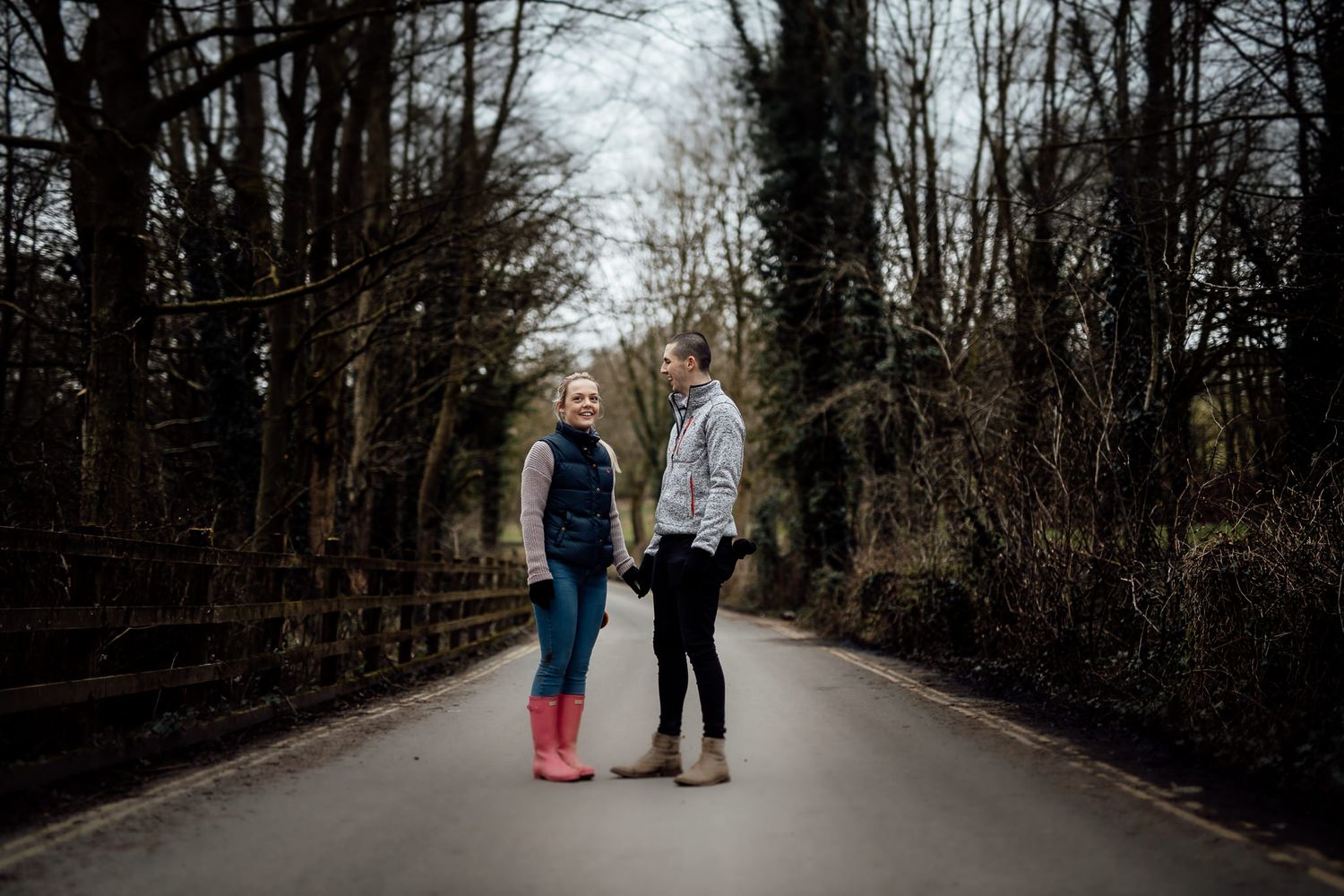 A couple walking along a tree-lined path during winter.