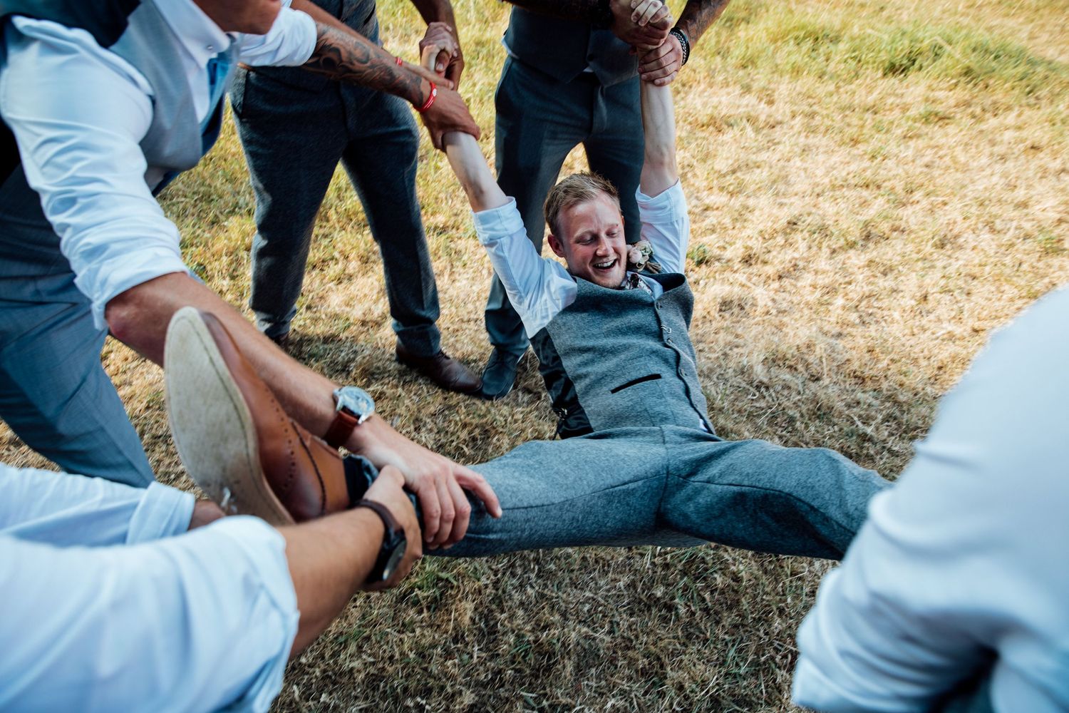 Casual outdoor gathering with people sitting on grass in summer.