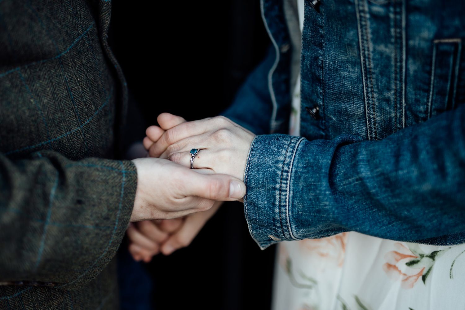 Close-up detail shots of hands and denim clothing against a dark background.