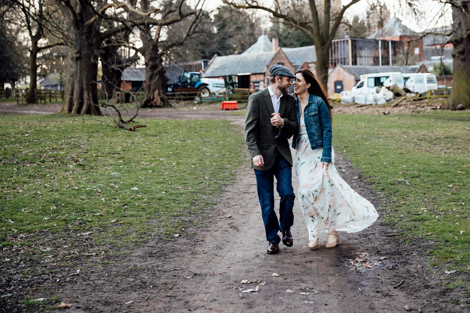 Couple walking through park grounds during autumn engagement session.