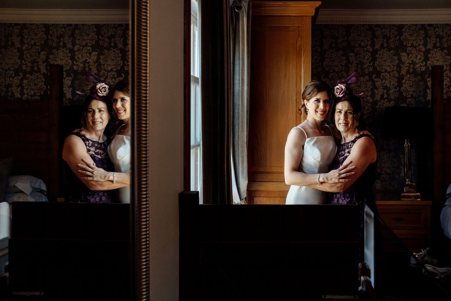 Elegant wedding couple shares intimate moments in a dimly lit venue with ornate wallpaper.
