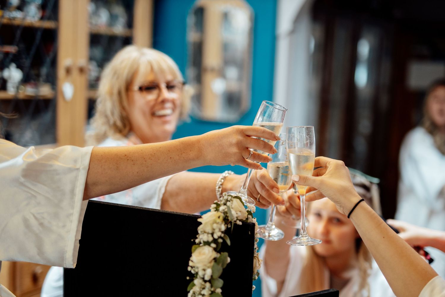 Hands raising champagne glasses for a wedding toast celebration.