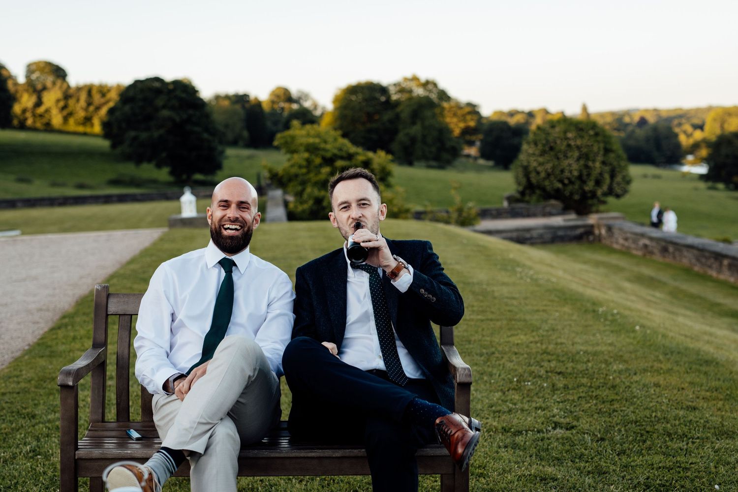Wedding guests enjoy cocktails and conversation on a scenic hillside.