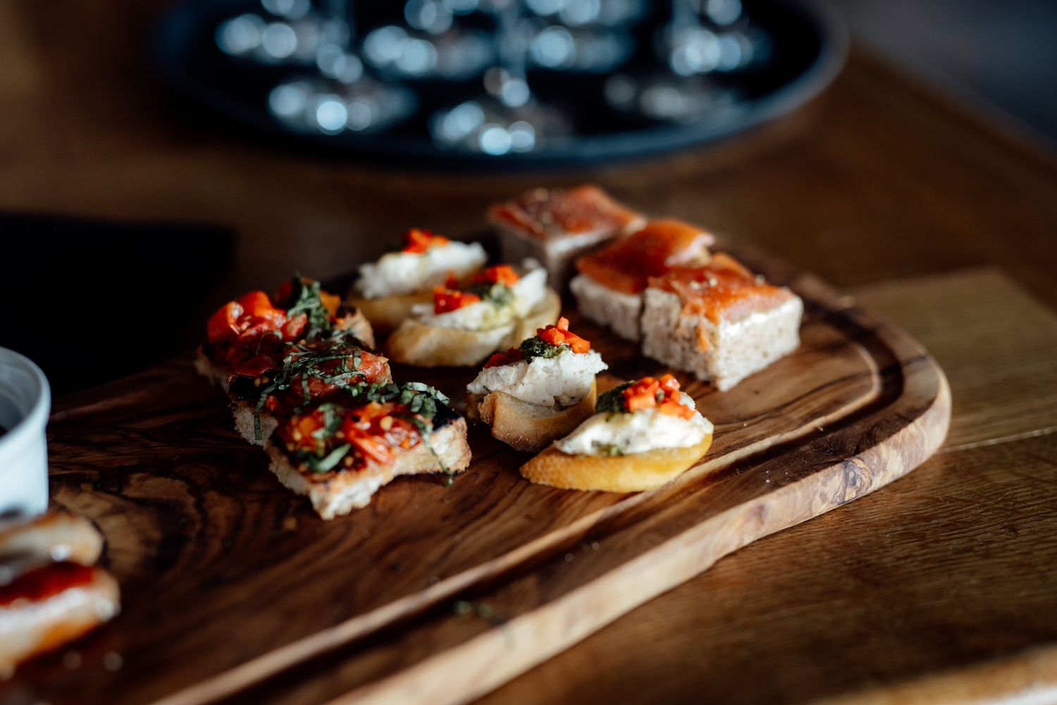 Artfully plated appetizers on rustic wooden serving boards in warm lighting.