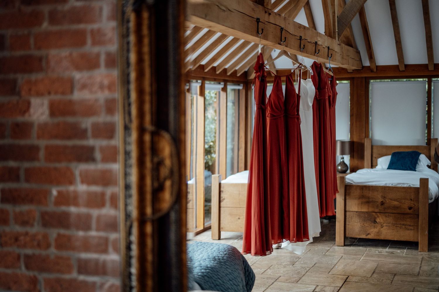 Interior of a rustic barn venue with exposed brick walls and wooden beams.