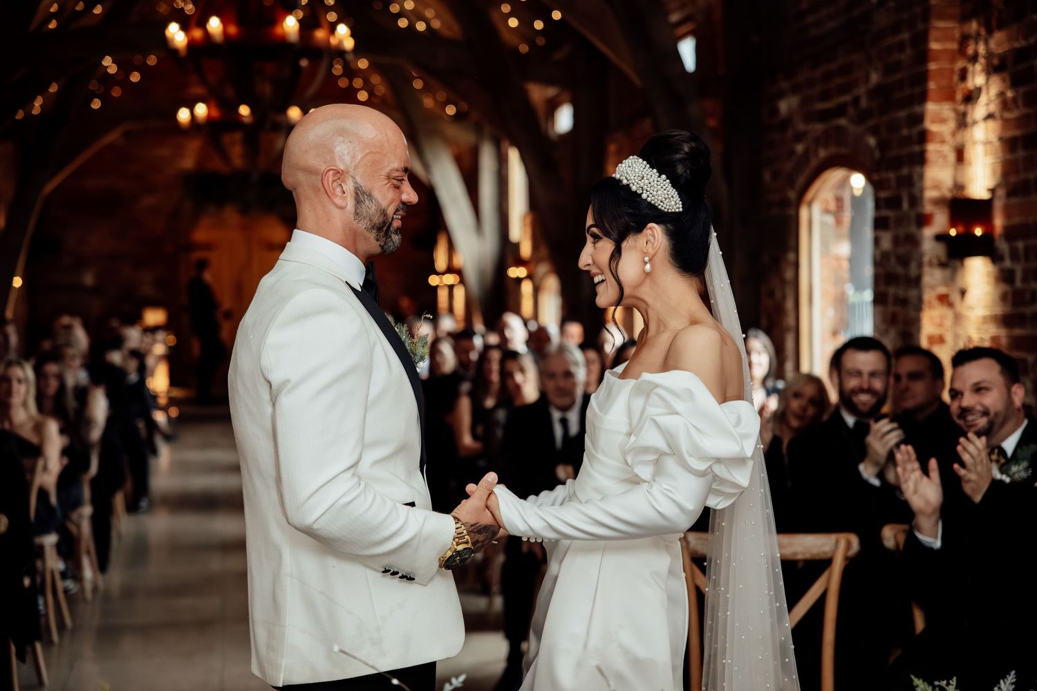 Newlyweds dancing together in an elegant brick-walled reception space.