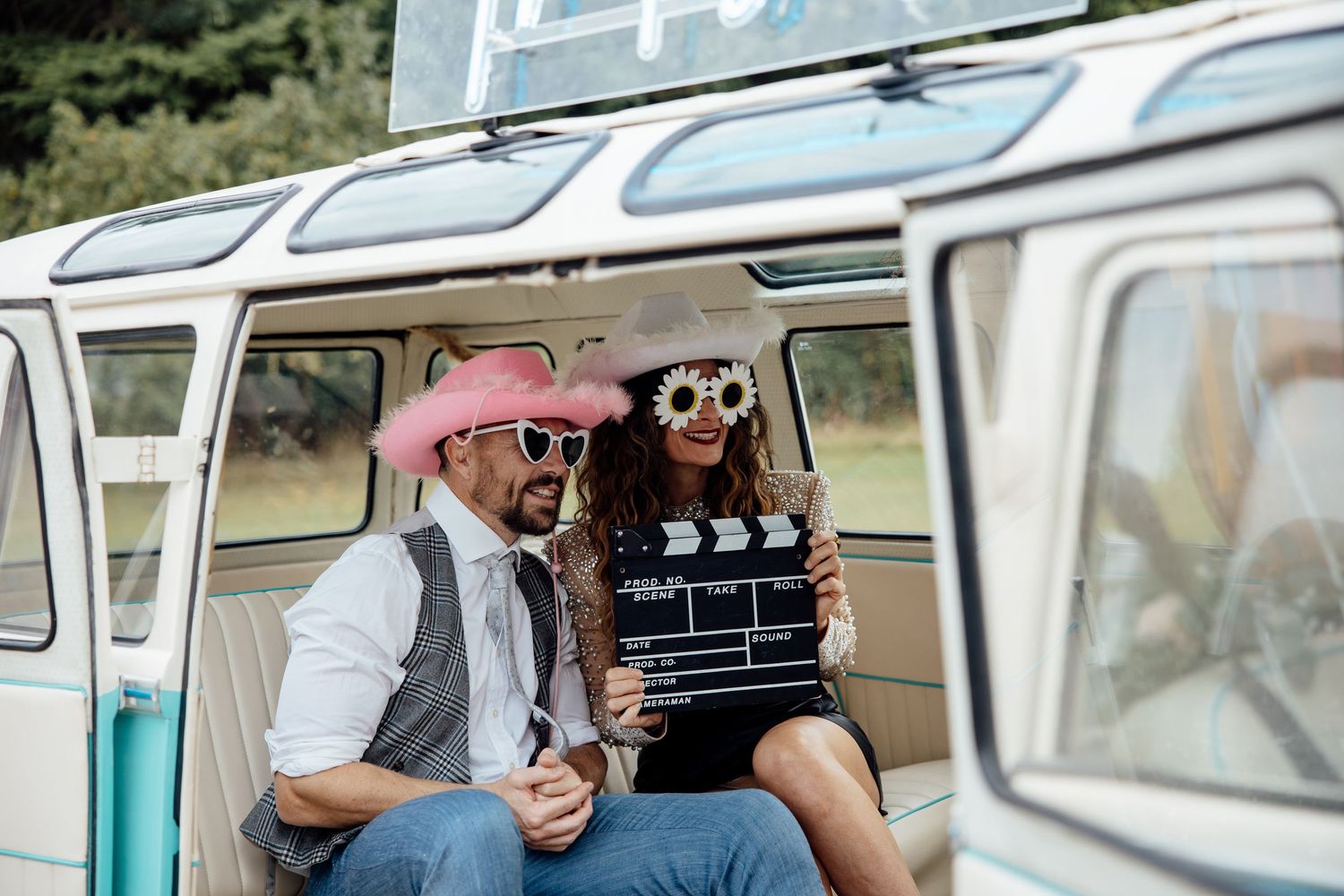 Vintage teal Volkswagen van with movie production clapperboard and retro styling.