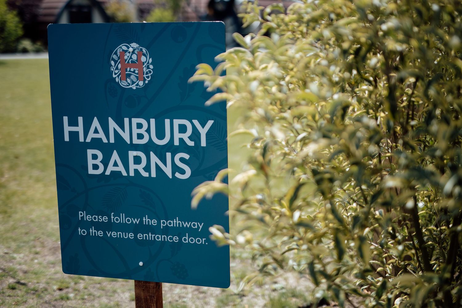 Decorative garden signs and foliage at an outdoor wedding venue.