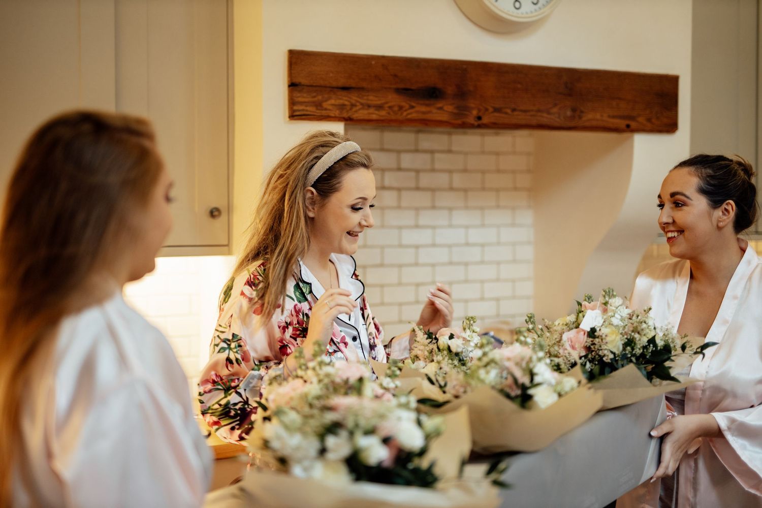 Wedding preparations in a bright room with floral arrangements on display.
