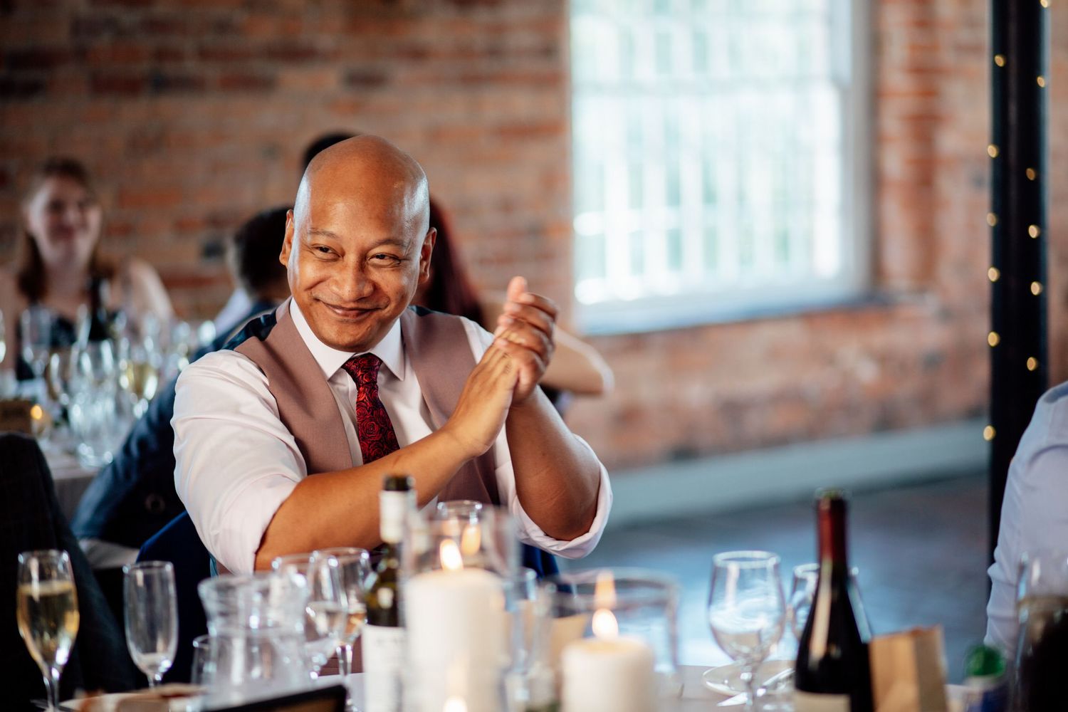 A bartender mixing drinks with enthusiasm at a wedding reception.