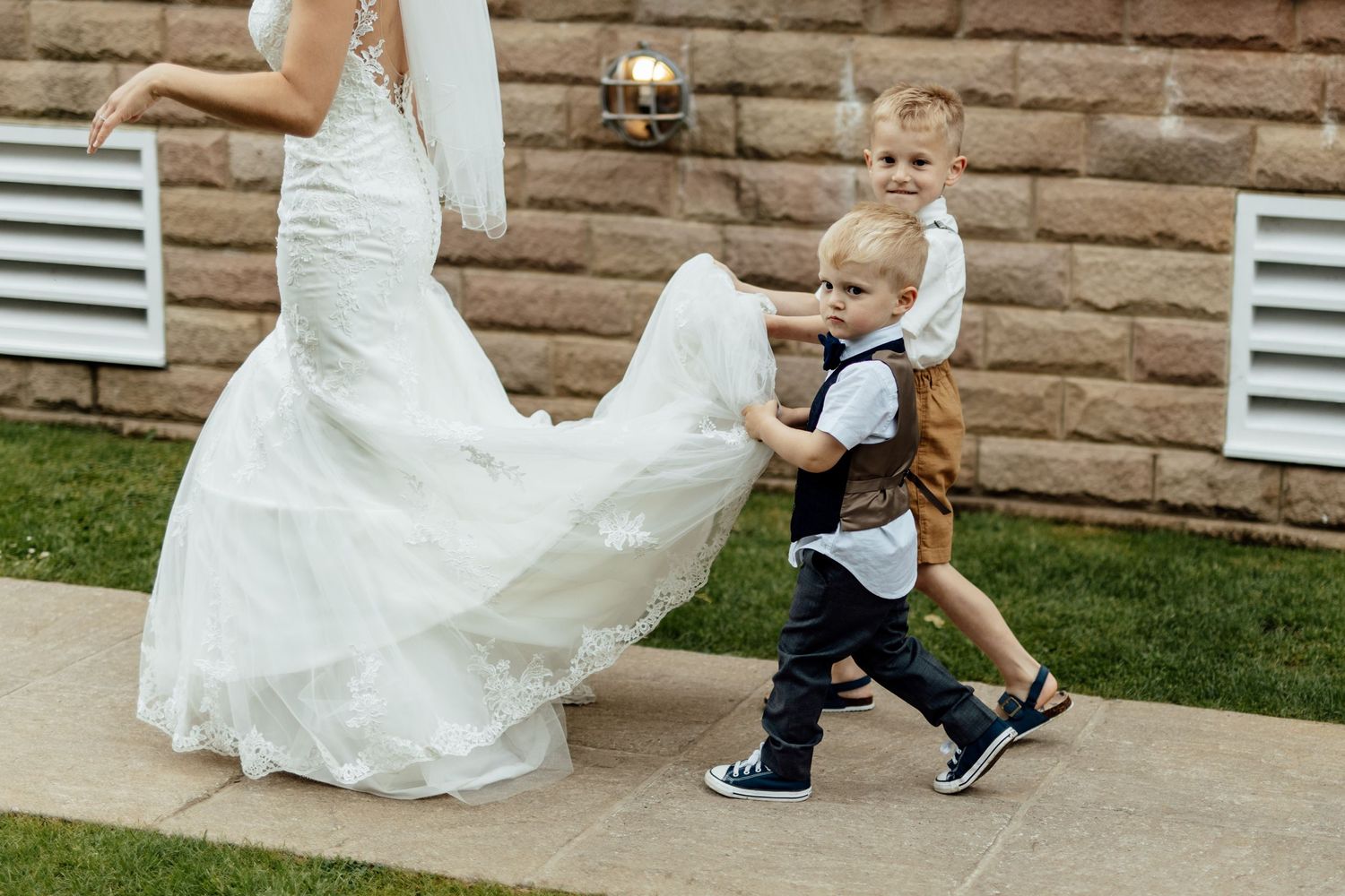 Playful wedding photo shoot on stone steps with white dress details.