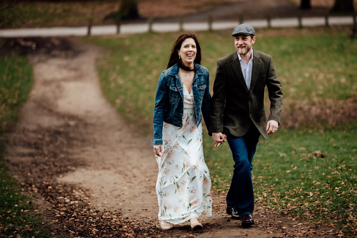 Couple walking together on a garden path surrounded by autumn foliage.