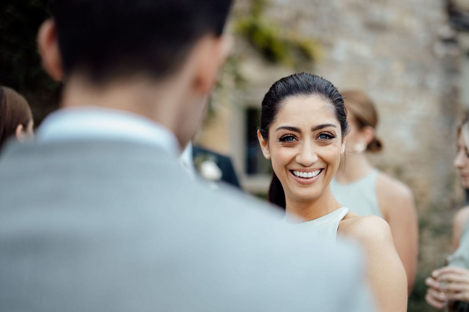 Close-up shot of joyful expressions during an outdoor wedding ceremony.