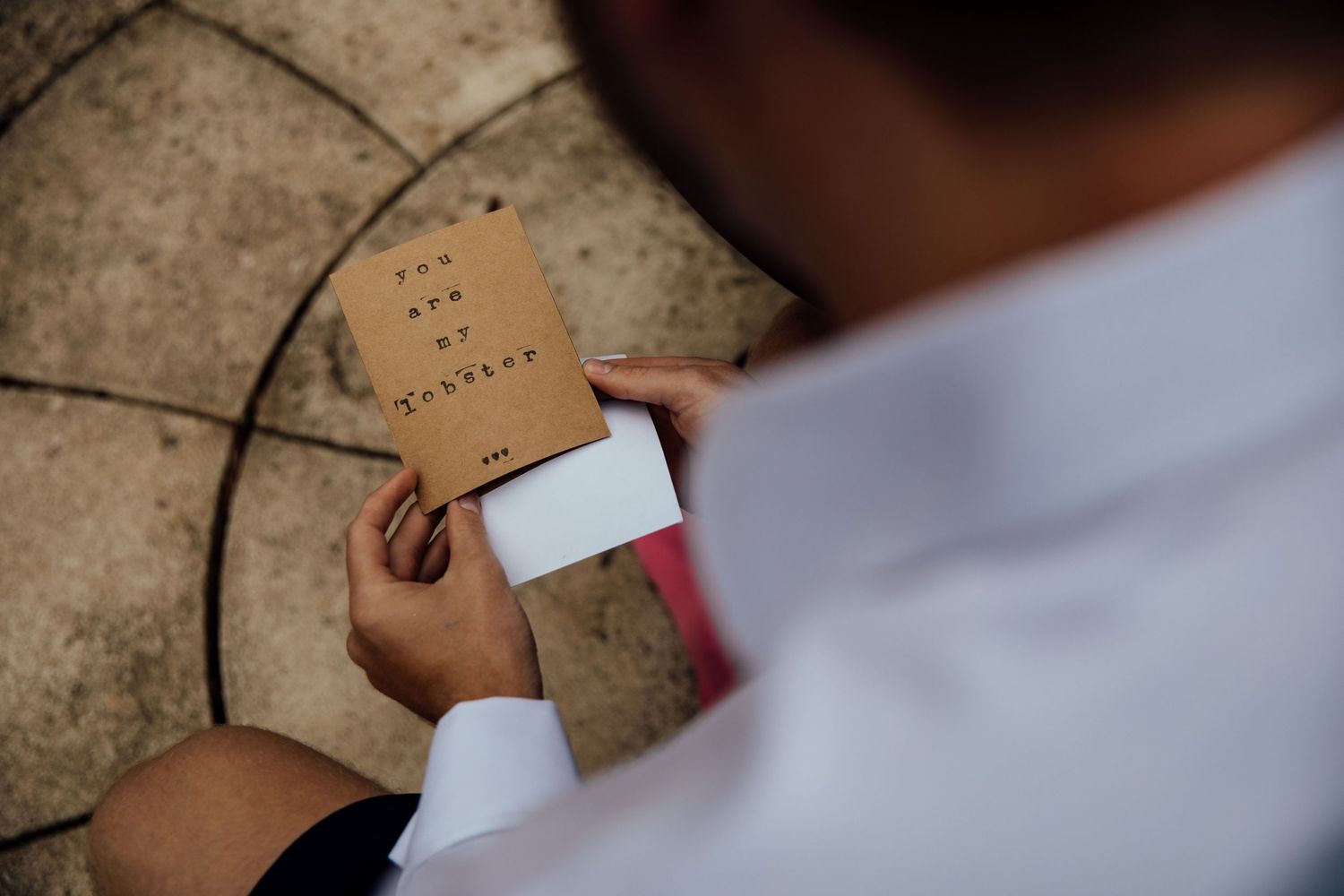 Wedding stationery and cards being arranged on textured stone surface.