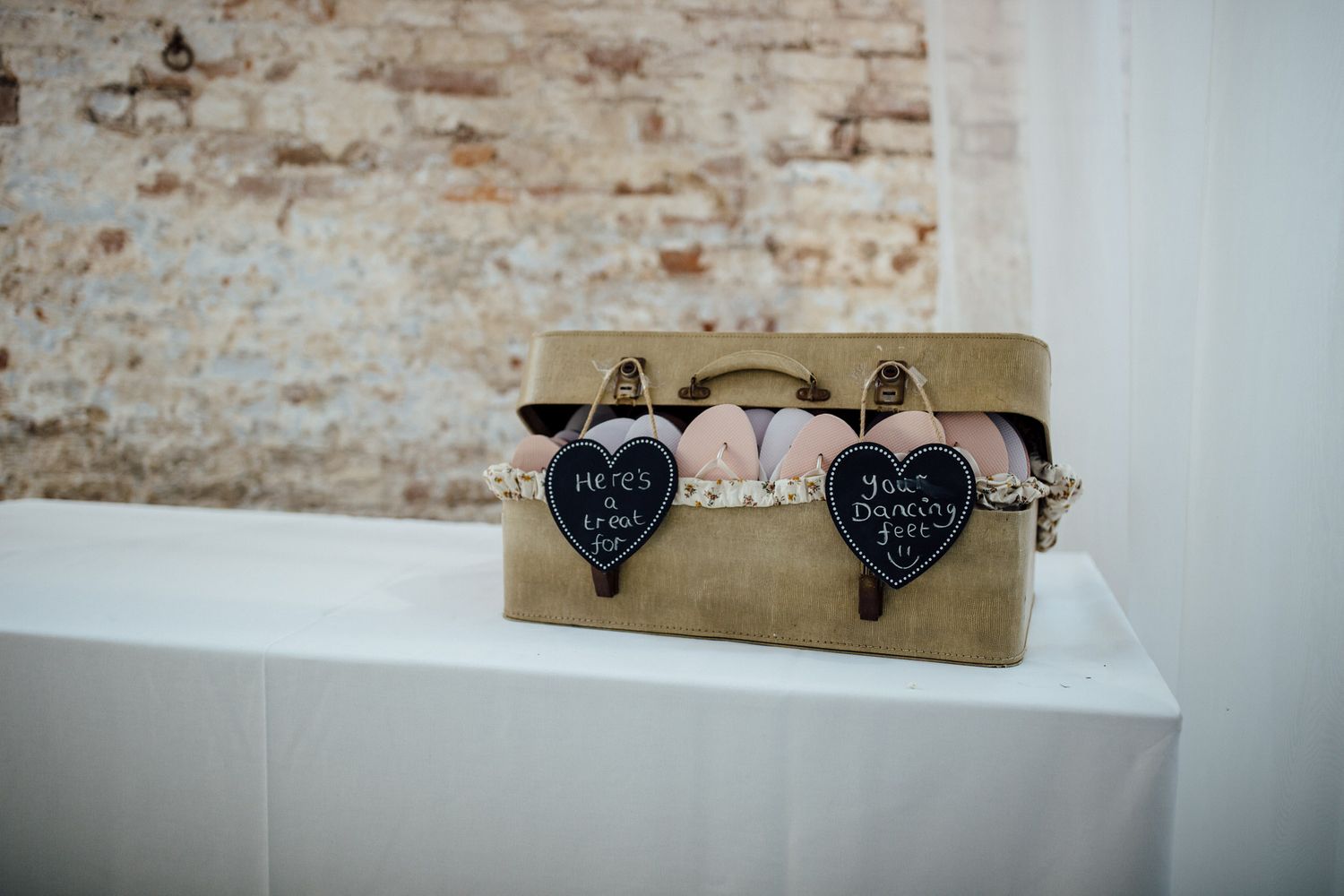 Rustic brick wall interior with minimalist decor and wedding signage.