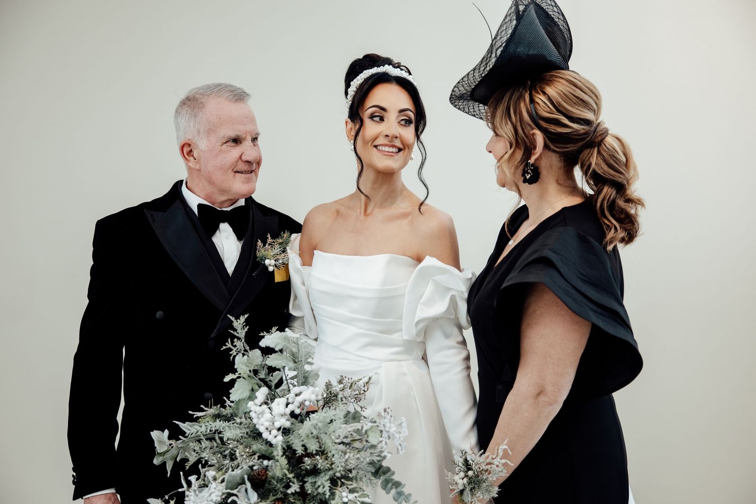 Wedding party members gather with beautiful winter bouquet featuring white and green florals.