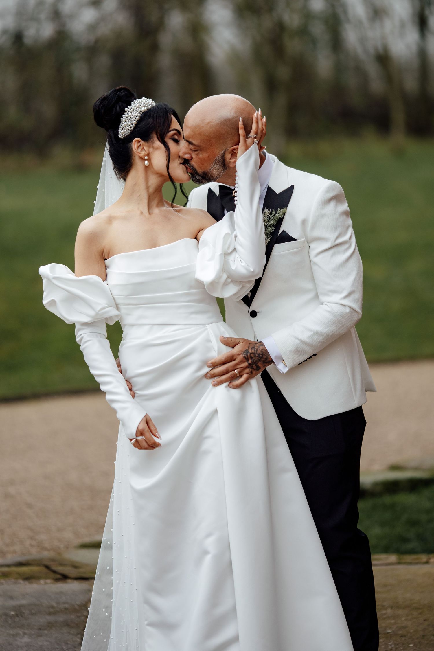 Romantic wedding couple in white attire sharing intimate moments during their photoshoot.