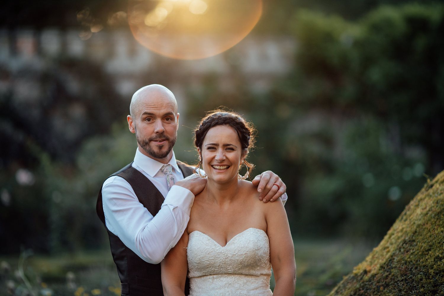 Romantic sunset wedding portraits captured in a lush outdoor garden setting.
