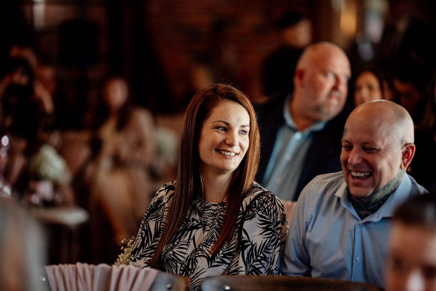 Reception guests enjoying candlelit dinner in rustic venue setting.