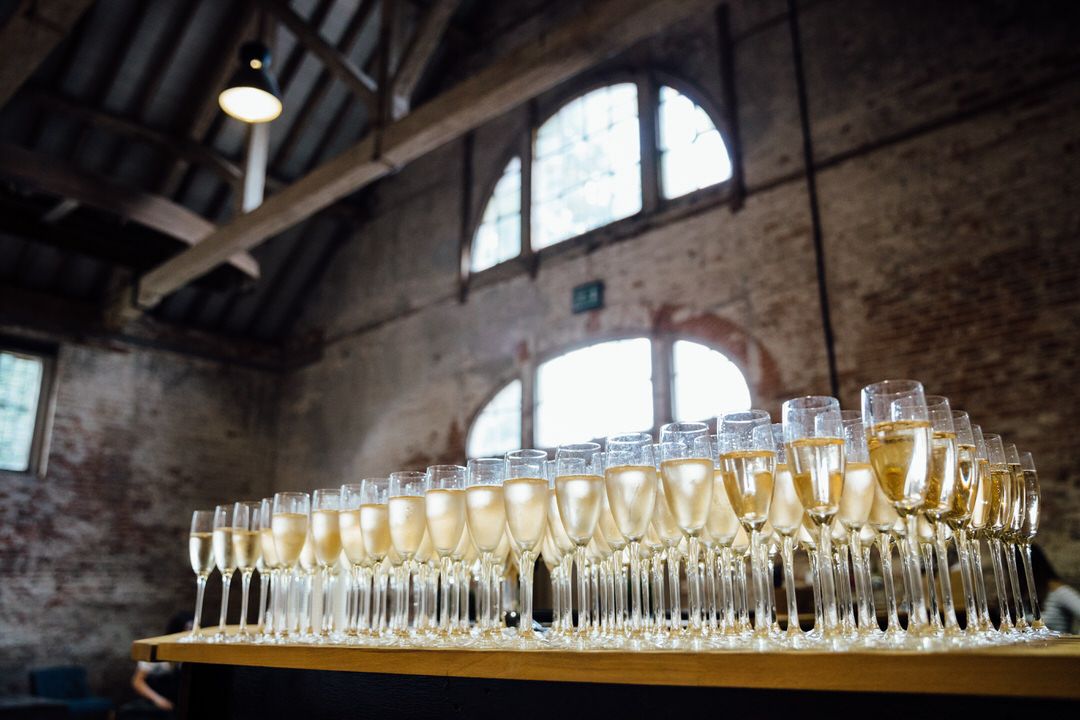 Long display of champagne glasses lined up at an elegant wedding reception.
