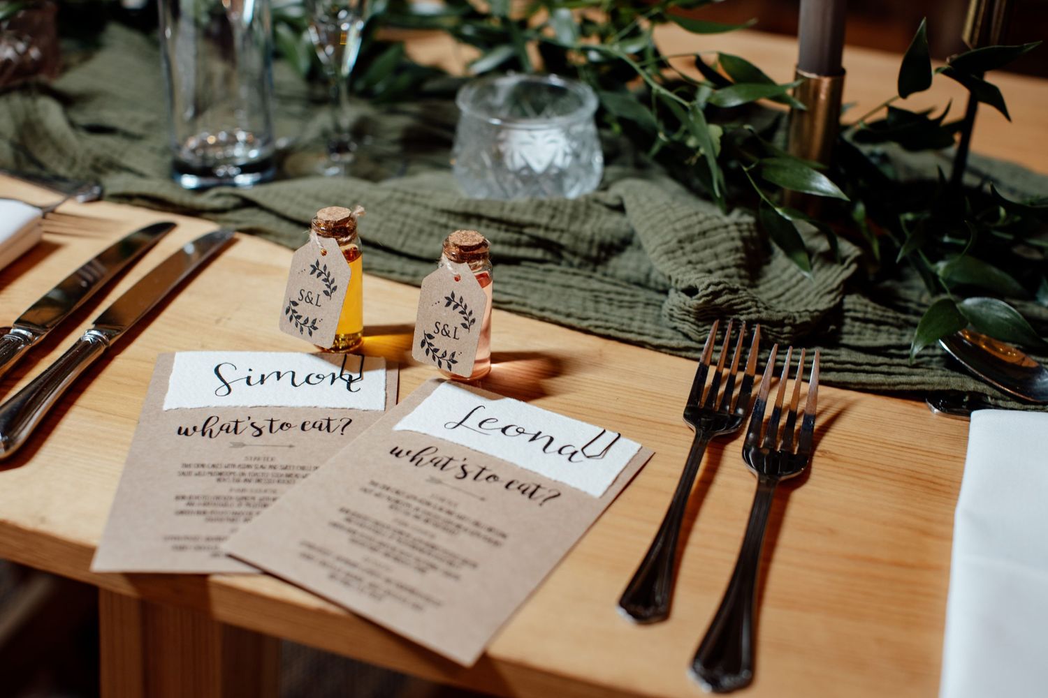 Wedding place settings with menus and cutlery arranged on wooden tables.