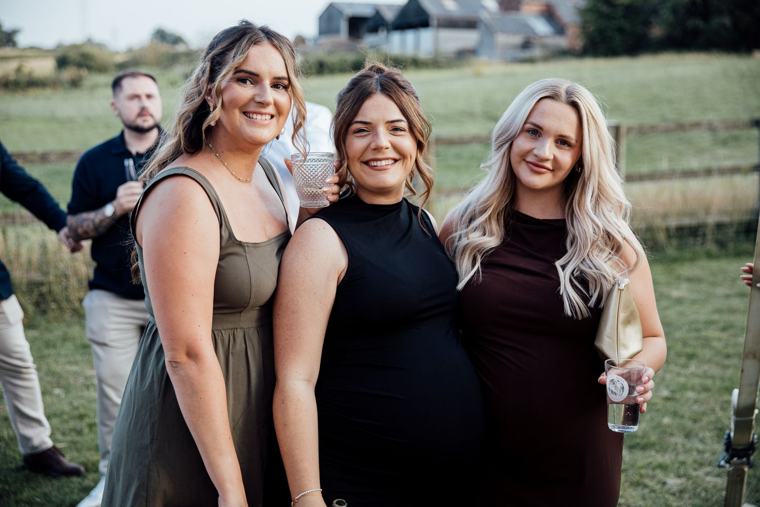 Wedding guests celebrate and smile together at outdoor reception.