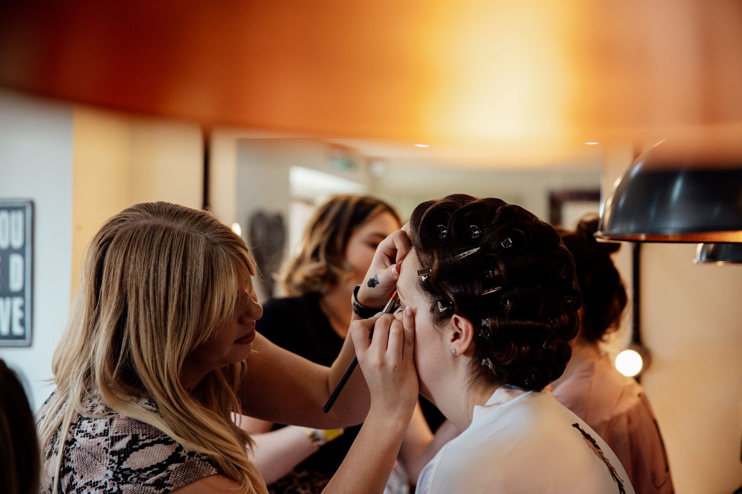 Behind the scenes of wedding preparation with makeup application in progress.