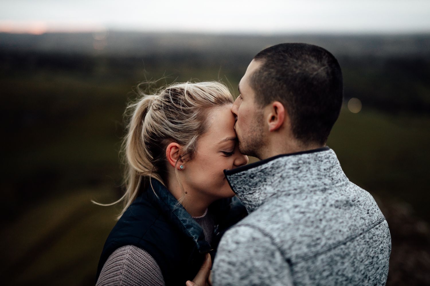 Tender embrace between a couple during a mountain engagement photoshoot.
