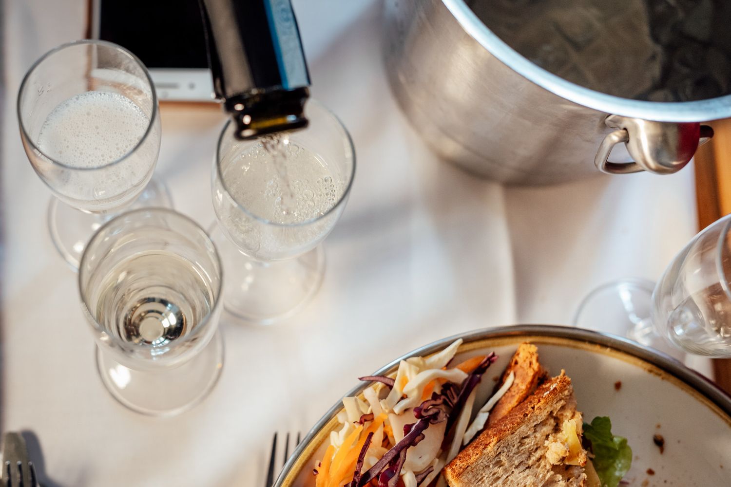 Elegant table setting with wine glasses and gourmet food presentation.