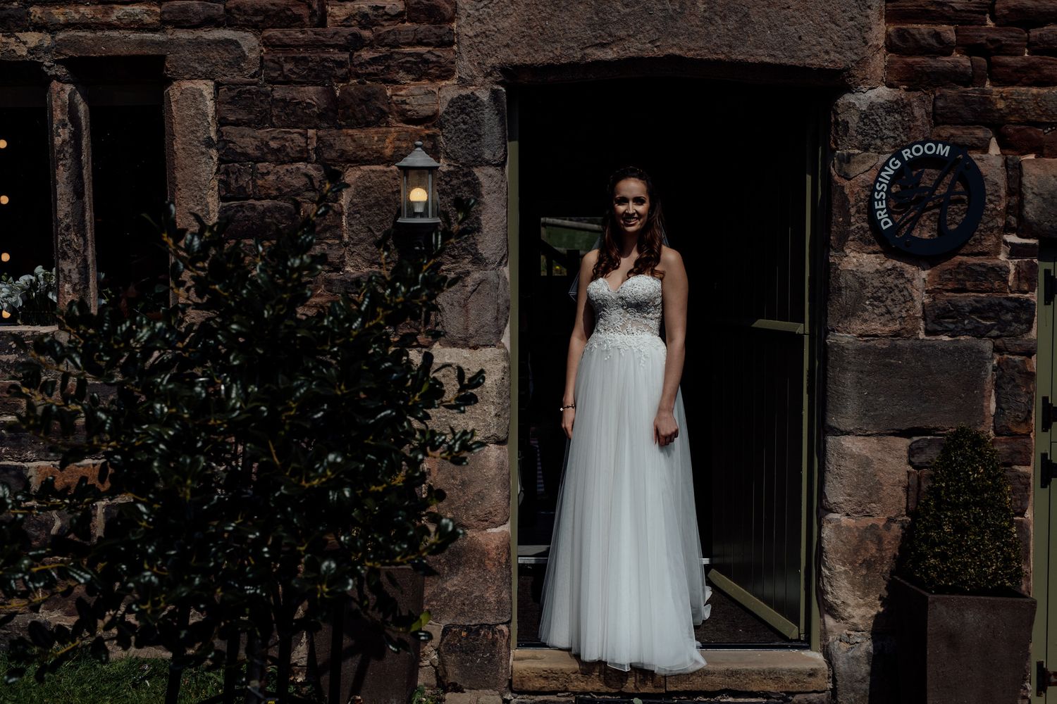 Stone building exterior with multiple arched doorways and white dress visible.