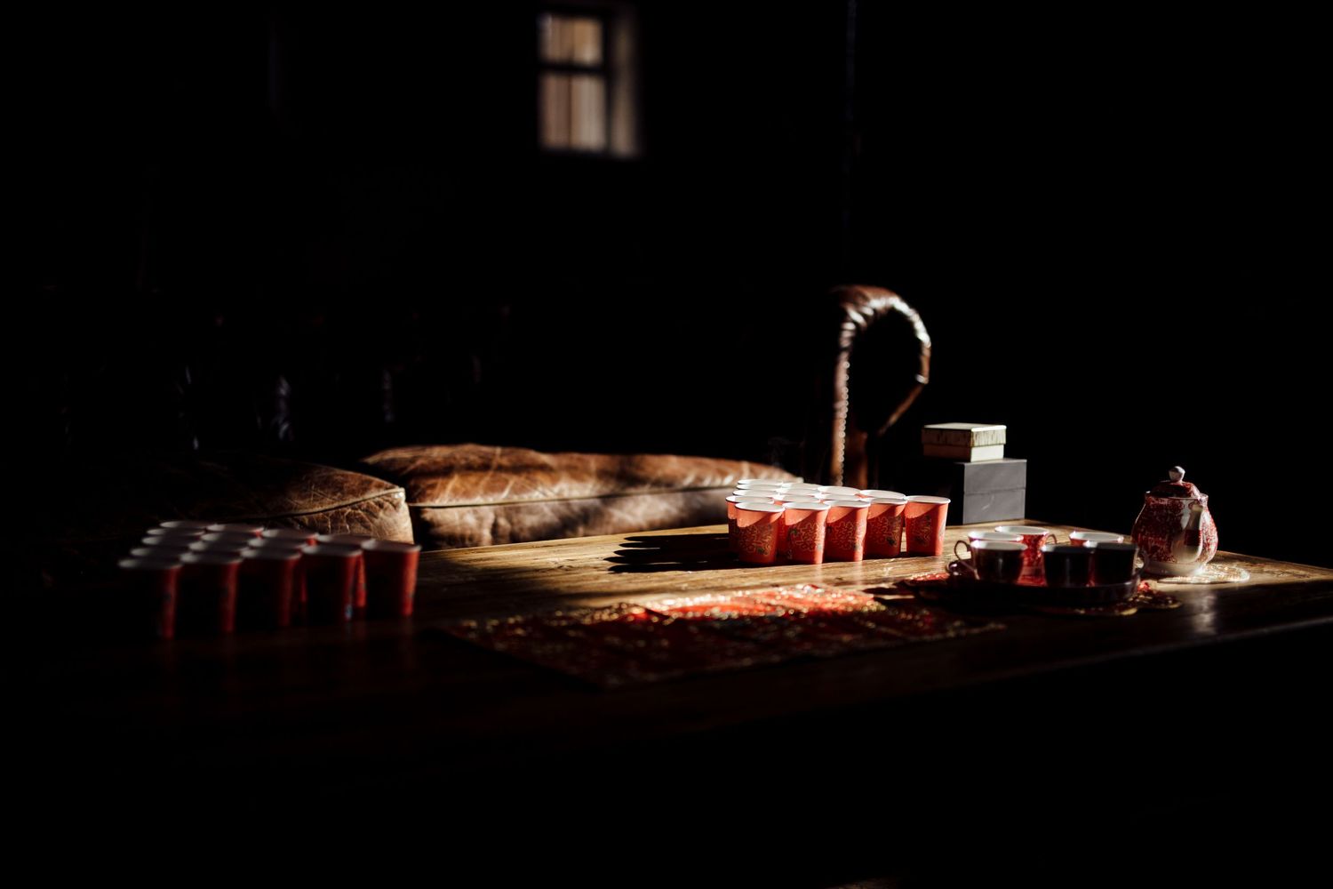 Moody wedding reception venue with dramatic lighting and table settings.