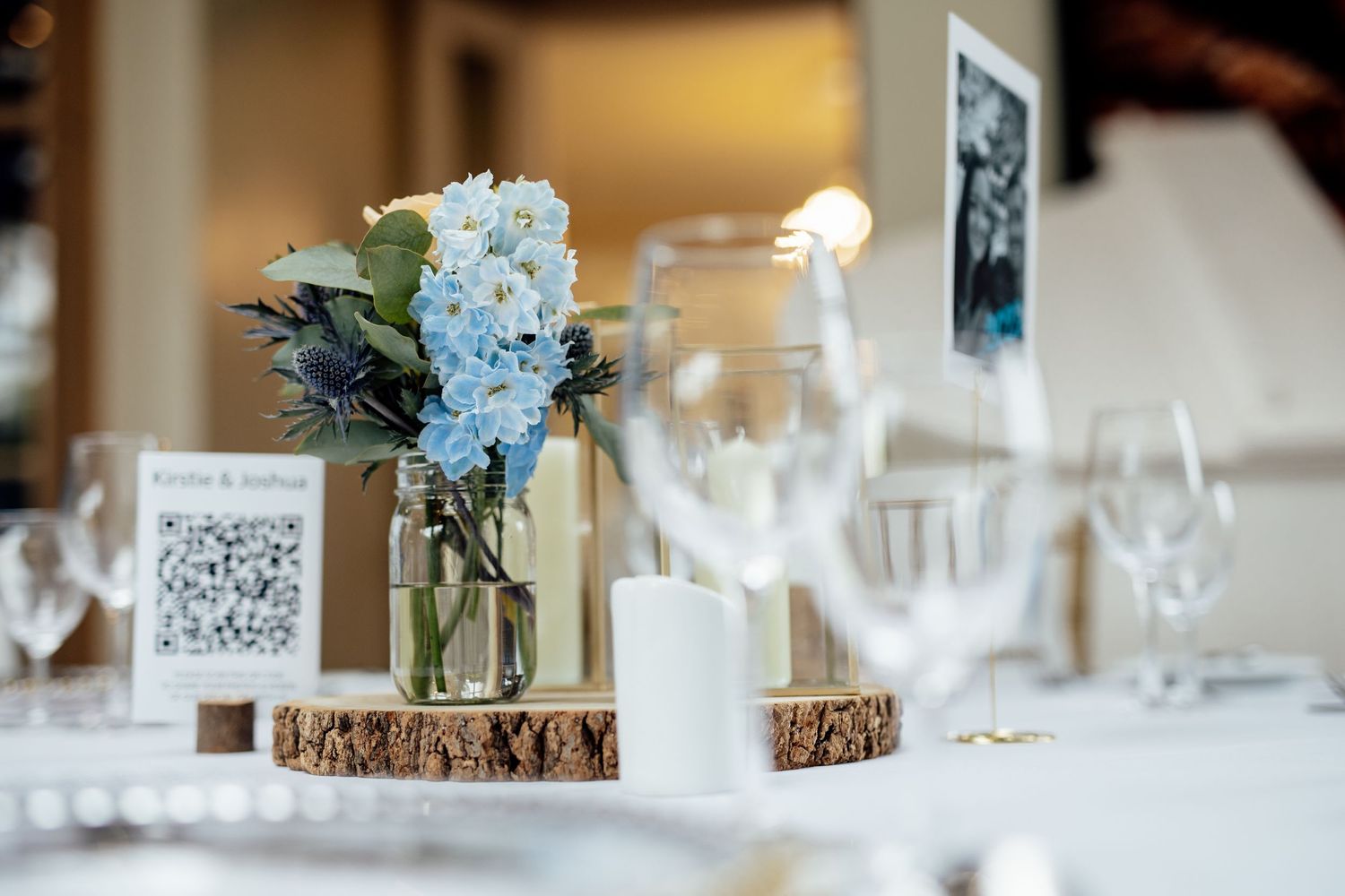 Wedding reception table settings with blue and white floral centerpieces.