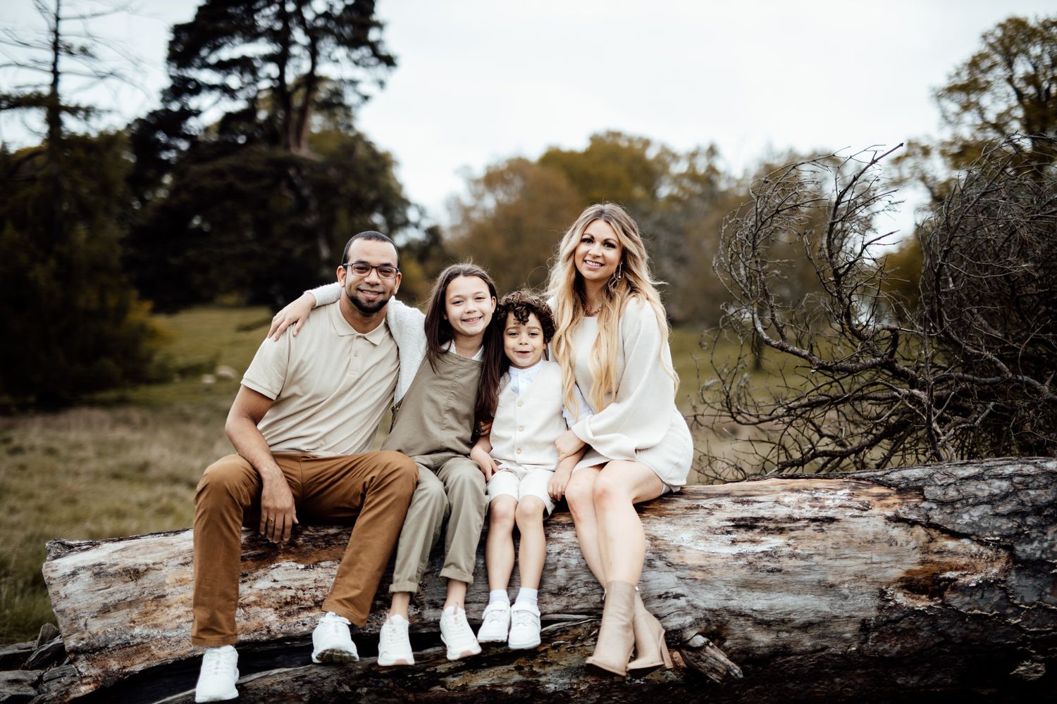 Family enjoying a relaxing outdoor photoshoot together on rocky terrain at sunset.