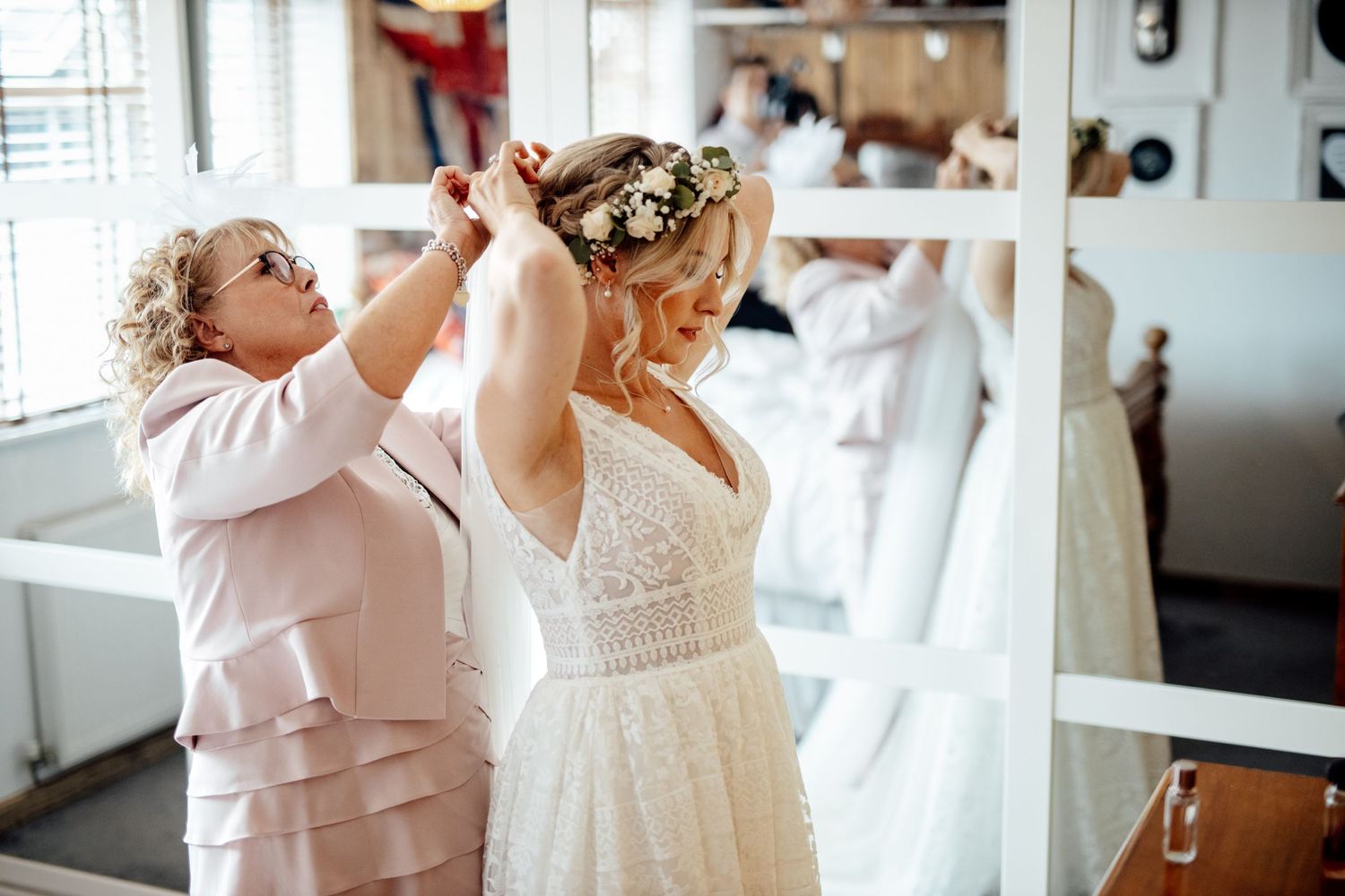 Bridal party in white robes helps bride prepare for wedding day.