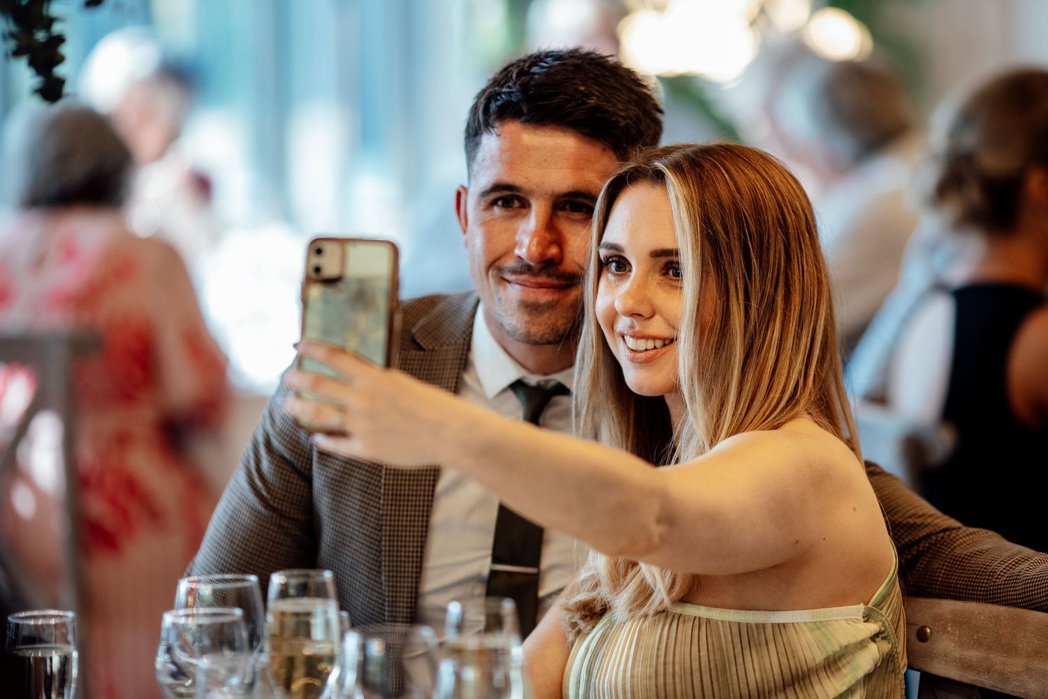 Wedding reception guests enjoy drinks and conversation at an indoor venue.