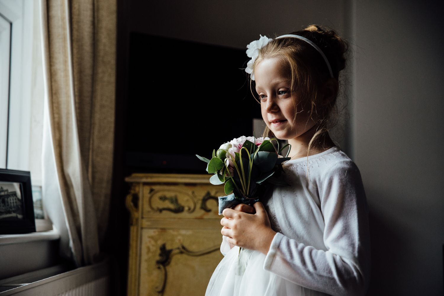 Candid getting ready moments during wedding preparations in a sunlit room.