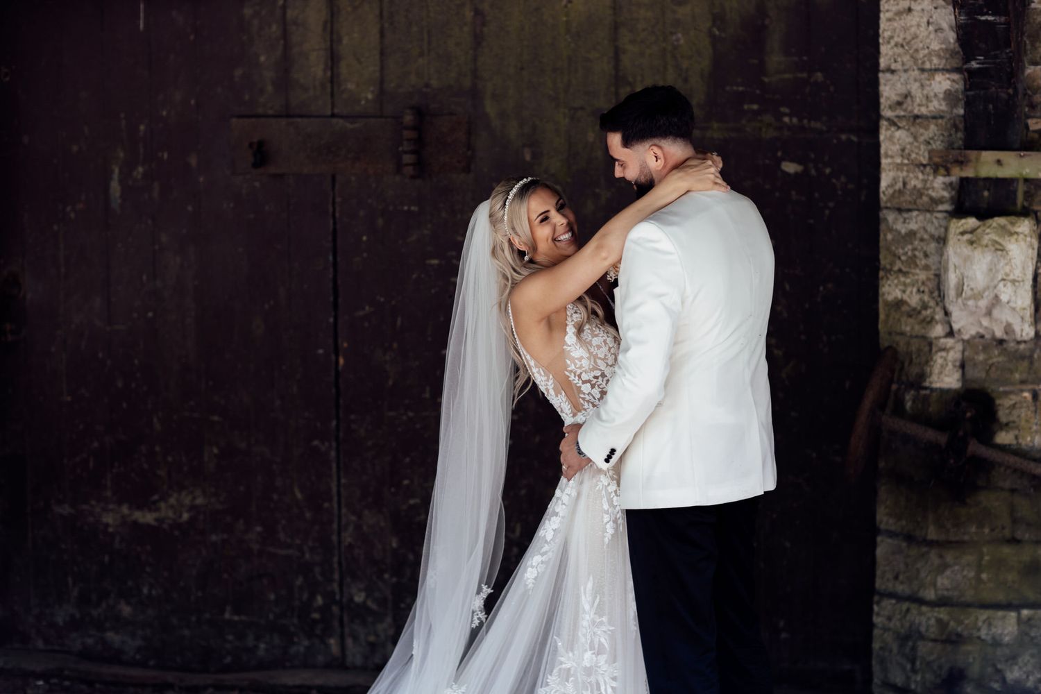 Romantic dance moments captured in rustic venue with stone walls and dramatic lighting.