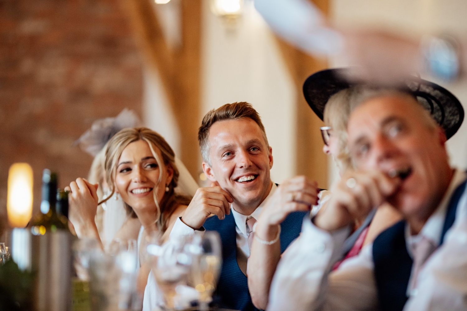 Candid reception moment showing guests laughing and enjoying celebration.
