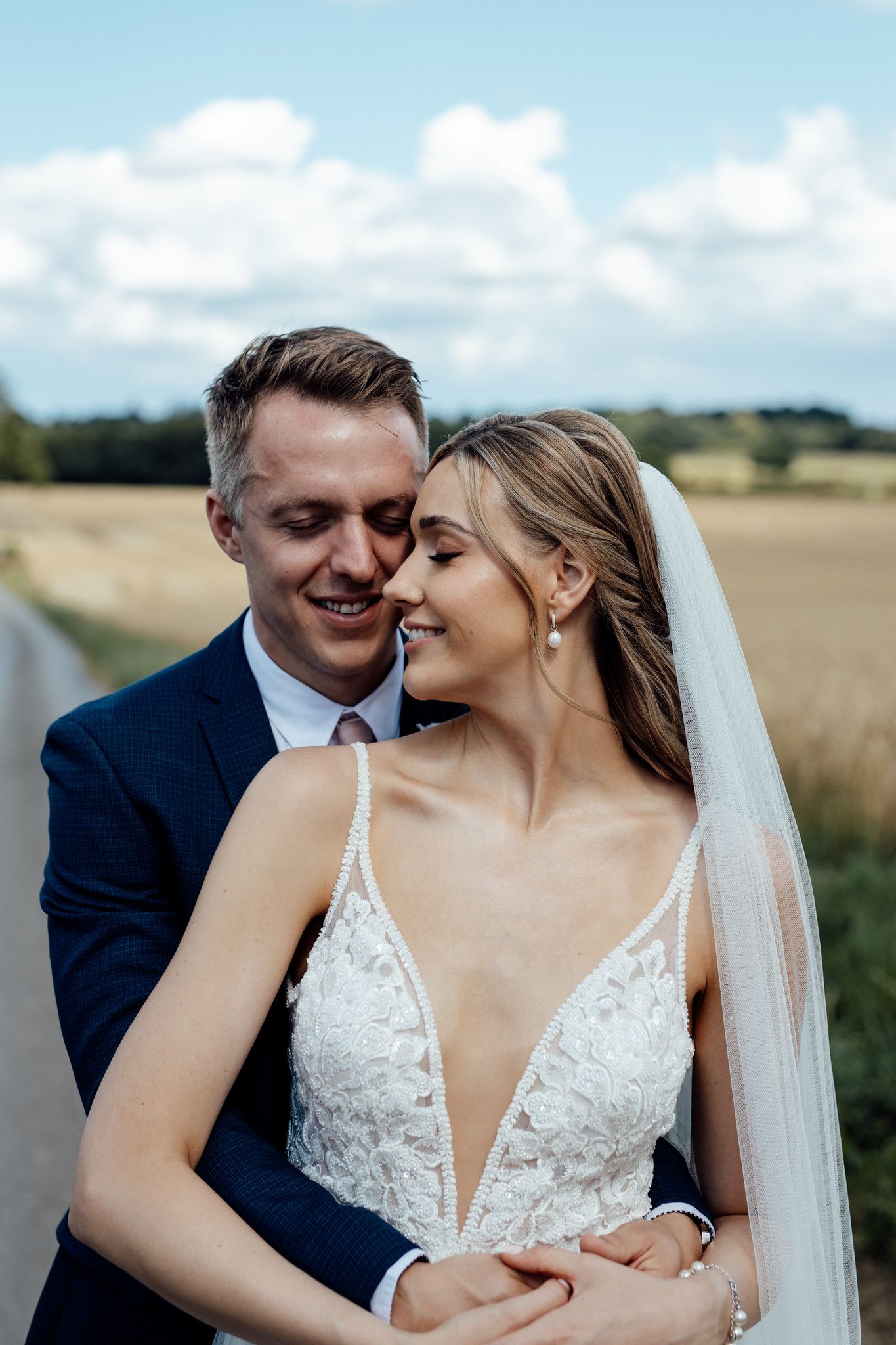 Intimate wedding portraits taken in a scenic countryside setting with natural lighting.
