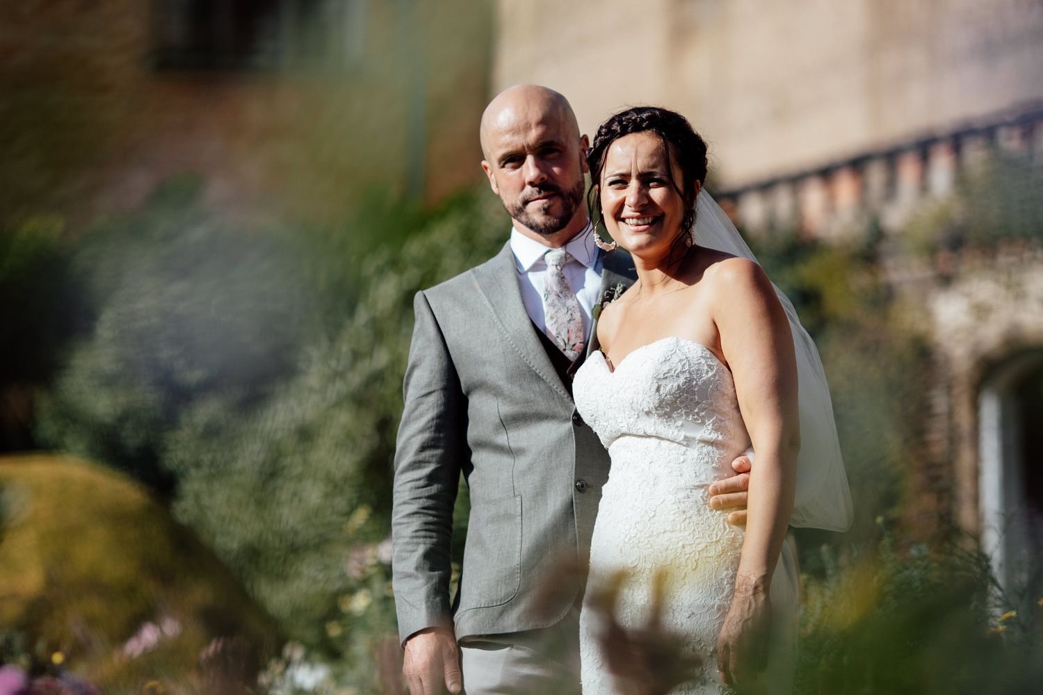 Candid wedding couple portraits captured in a beautiful outdoor garden setting.