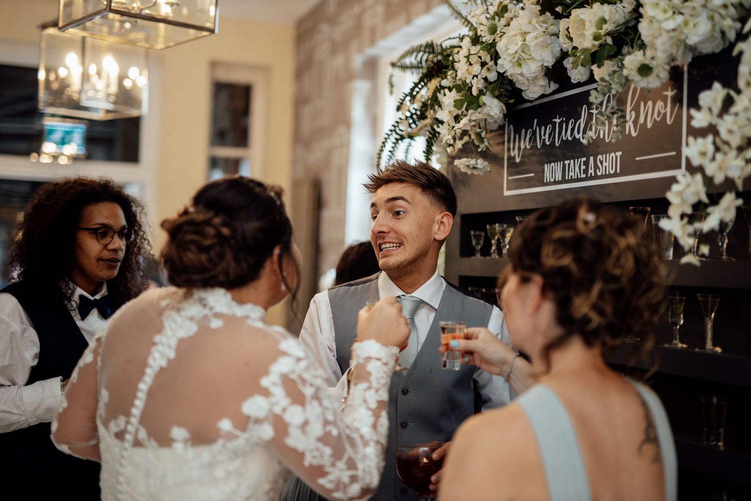 Wedding reception venue decorated with white floral arrangements and elegant lighting.